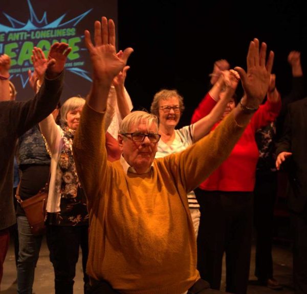 Theatre company group performing with hands in air
